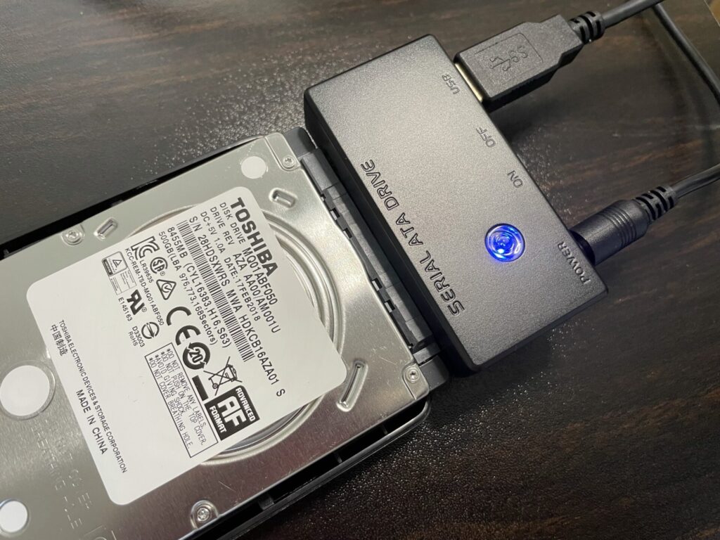 SATAのHDDをUSB接続するアダプタを、HDDに取り付けた画像